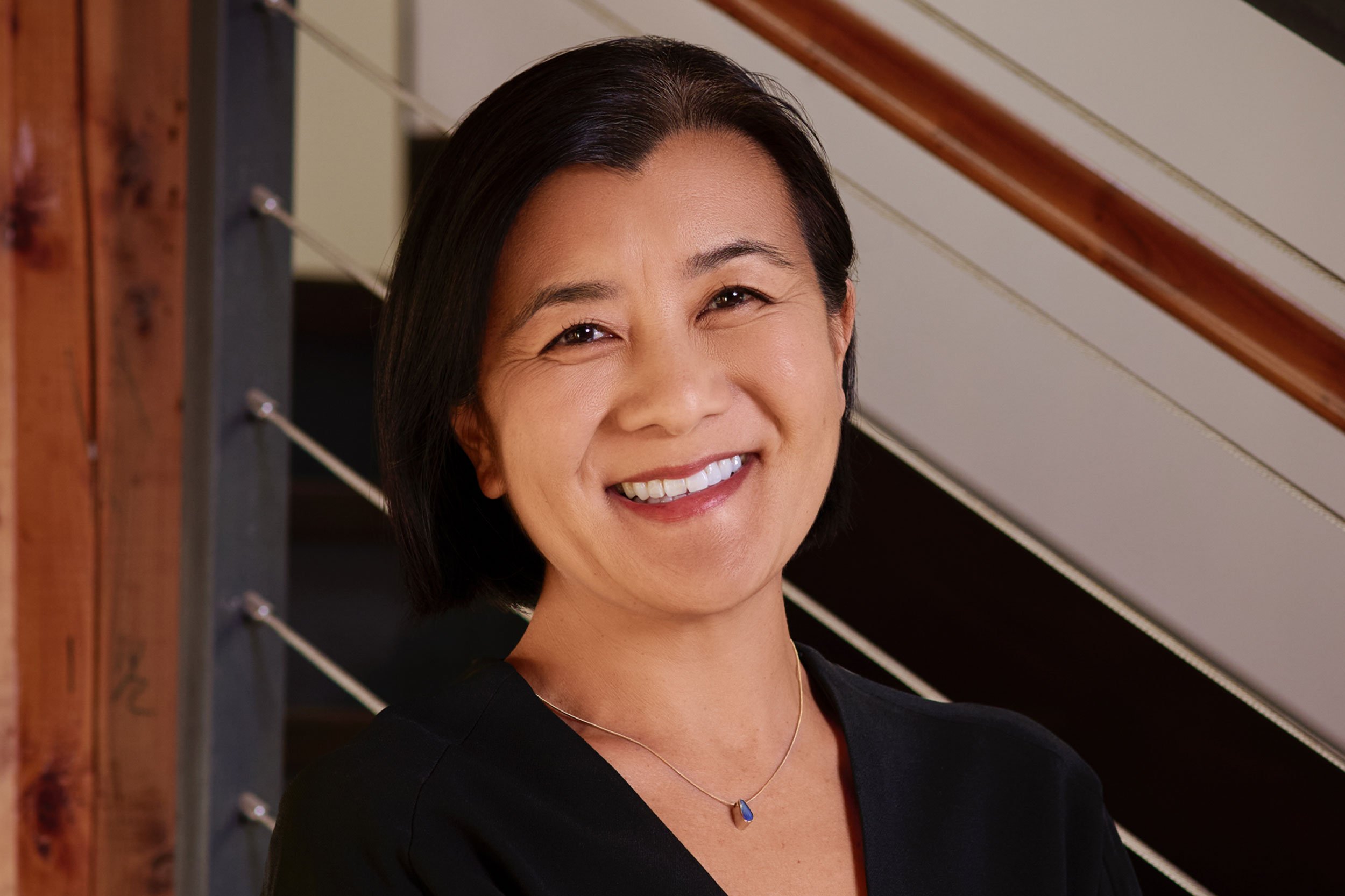 Alison Morita in black in front of office stairs