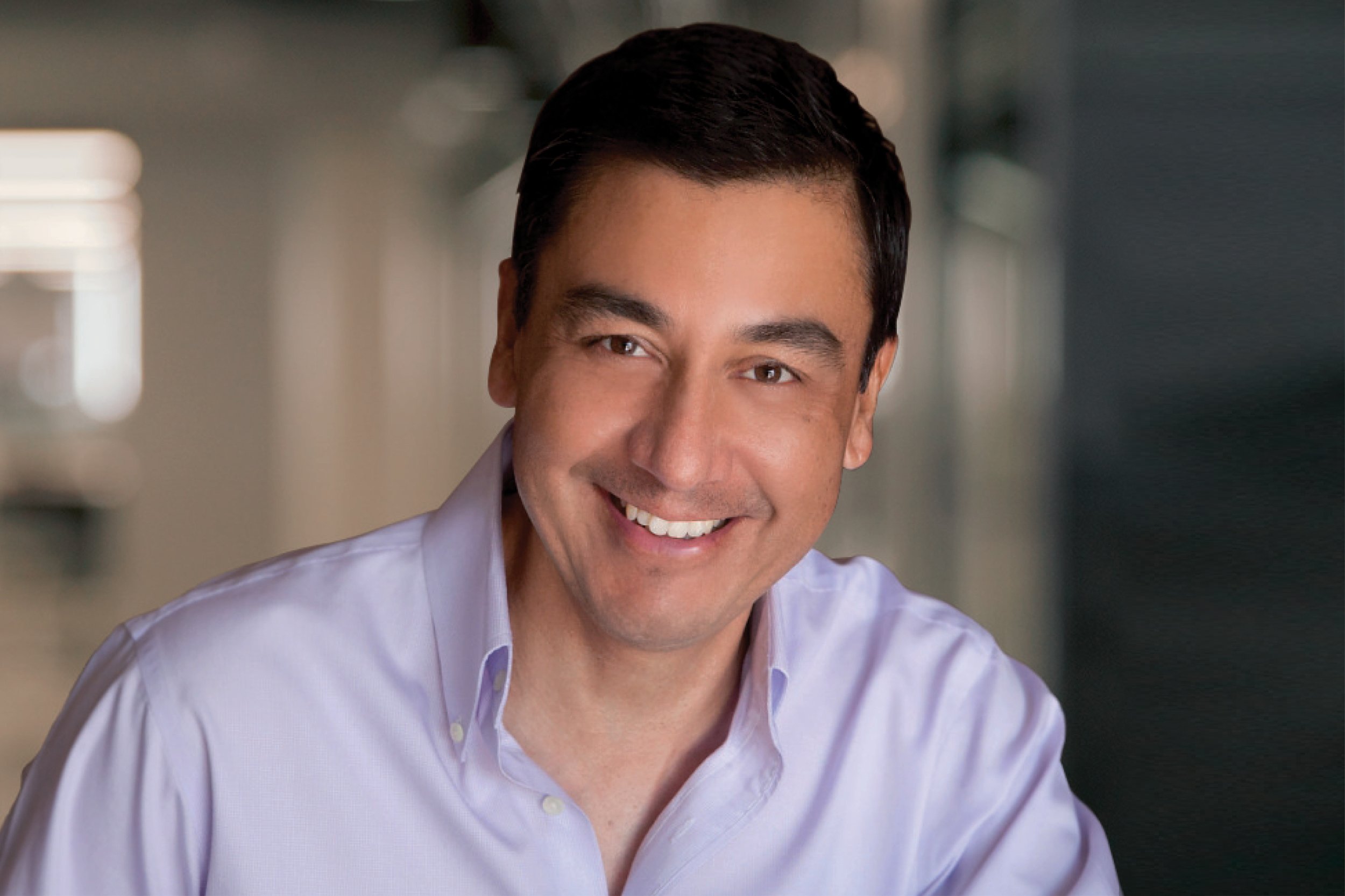 Portrait of Arnie Martinez, Vice President, wearing a white button-up shirt in an indoor setting.
